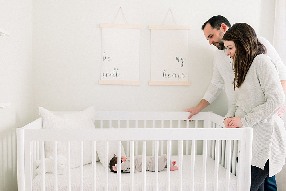 couple standing by baby's crib