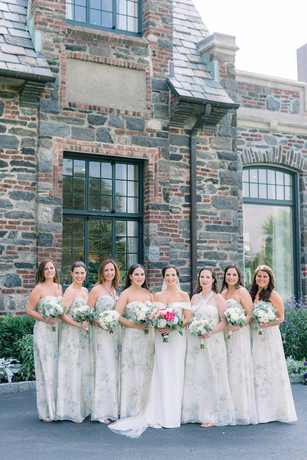 A bride holds her bouquet with her bridesmaids outside one of the best Westchester wedding venues