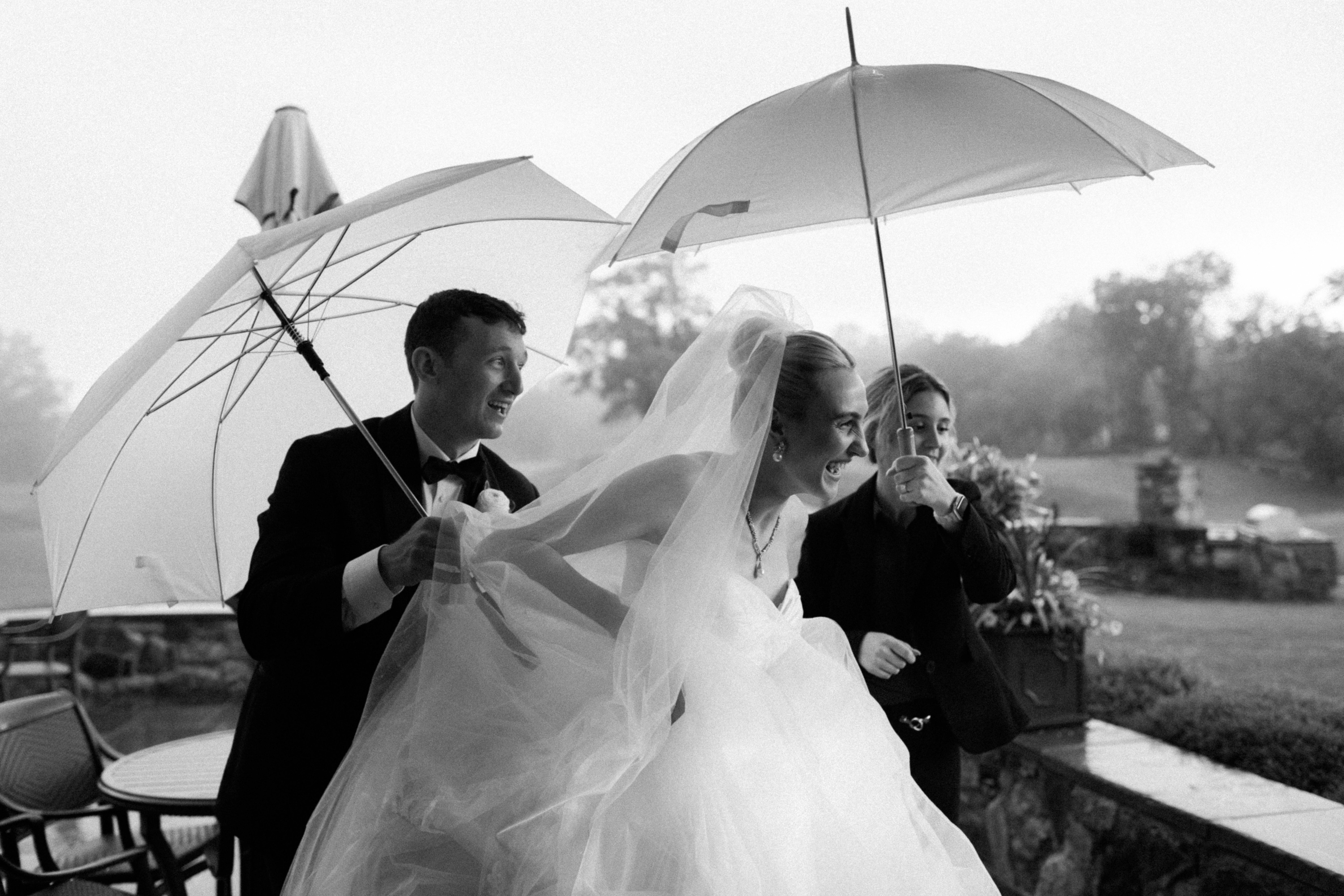 Newlyweds run, laugh and smile big while escaping the rain on their wedding day